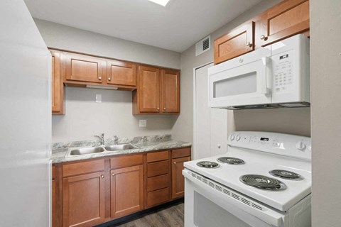 a kitchen with white appliances and wooden cabinets