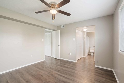 an empty living room with a ceiling fan