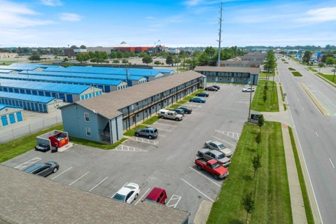 an aerial view of a building with cars parked in a parking lot