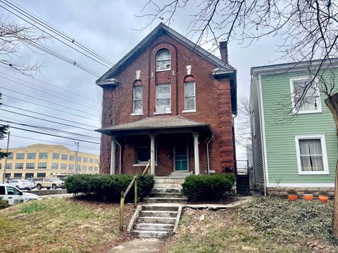 an old brick house on a hill with stairs