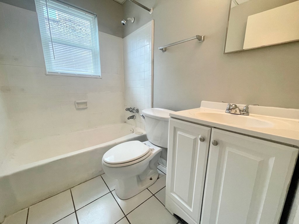 a bathroom with a toilet and a tub and a sink