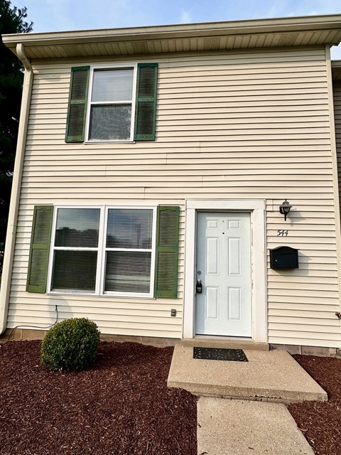 the front of a house with a white door