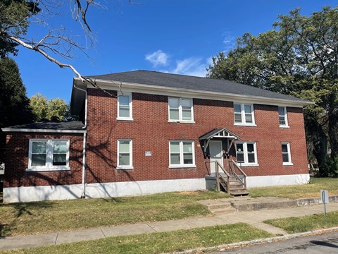 a red brick house with a porch and stairs