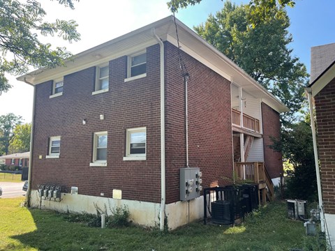 the back of a brick house with a power line