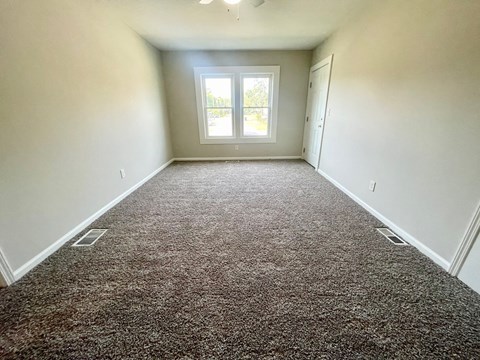 an empty room with carpet and a window