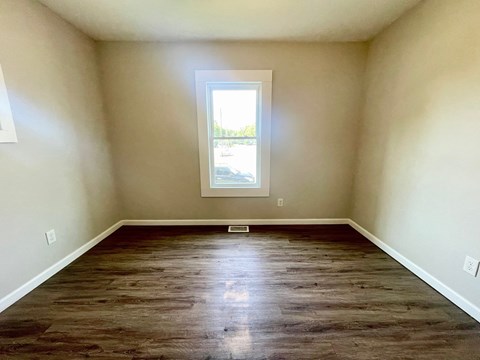 a empty room with wooden floors and a window