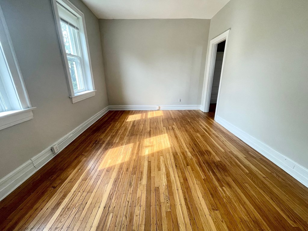 a living room with wood floors and white walls
