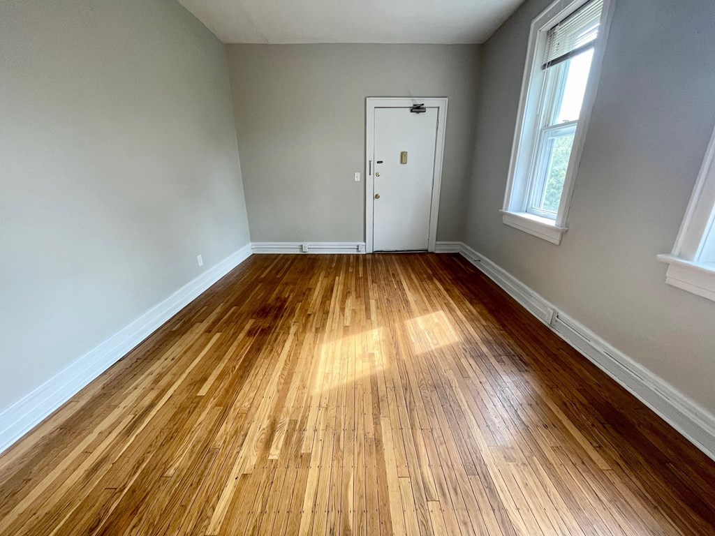 a living room with wood floors and a white door