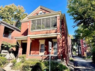 a brick house with a sidewalk in front of it
