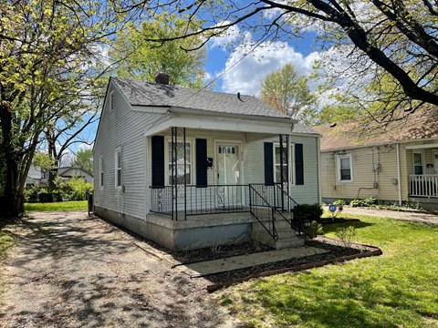 a white house with a front porch and a driveway