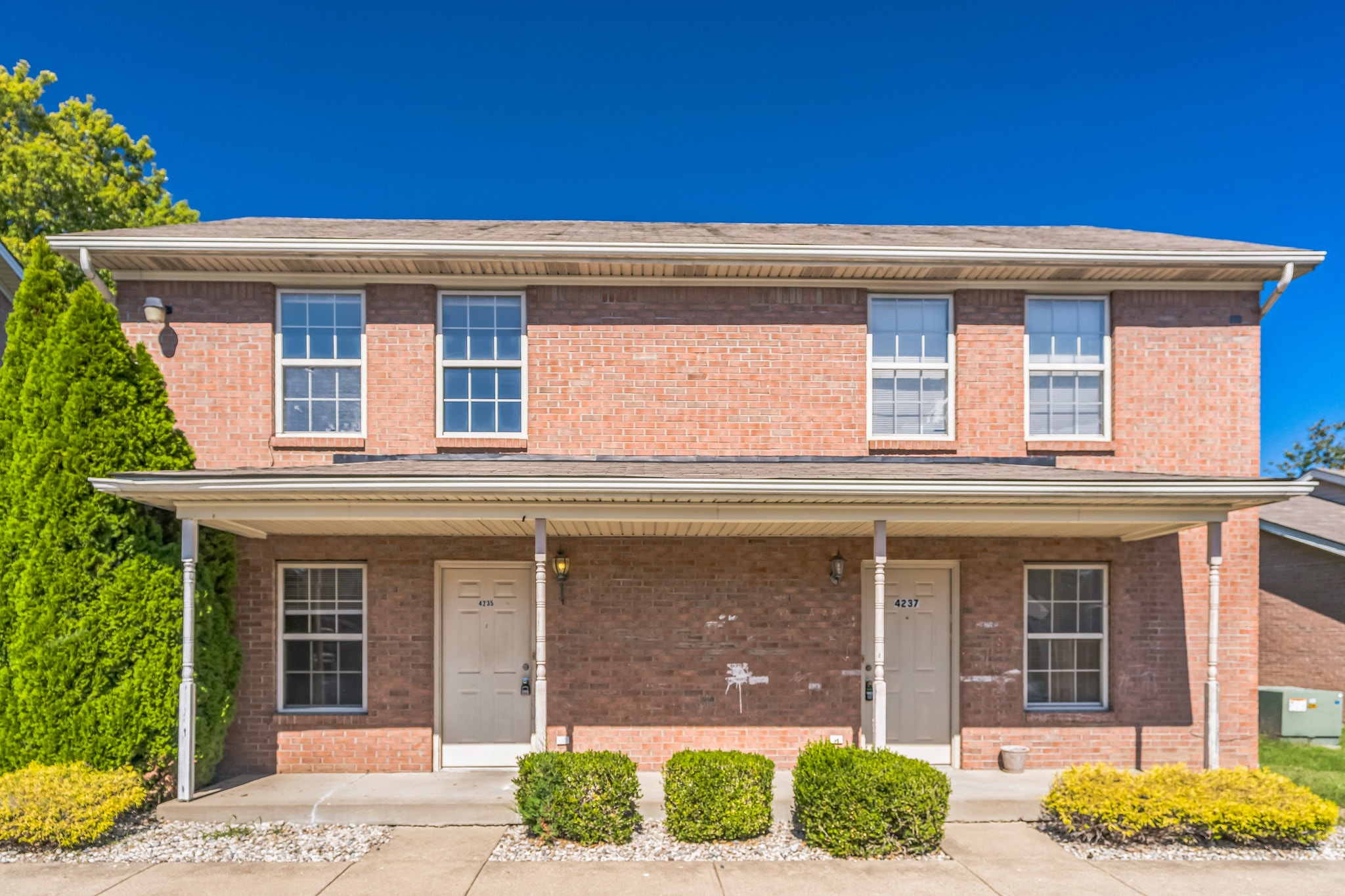 the front of a brick house with two doors