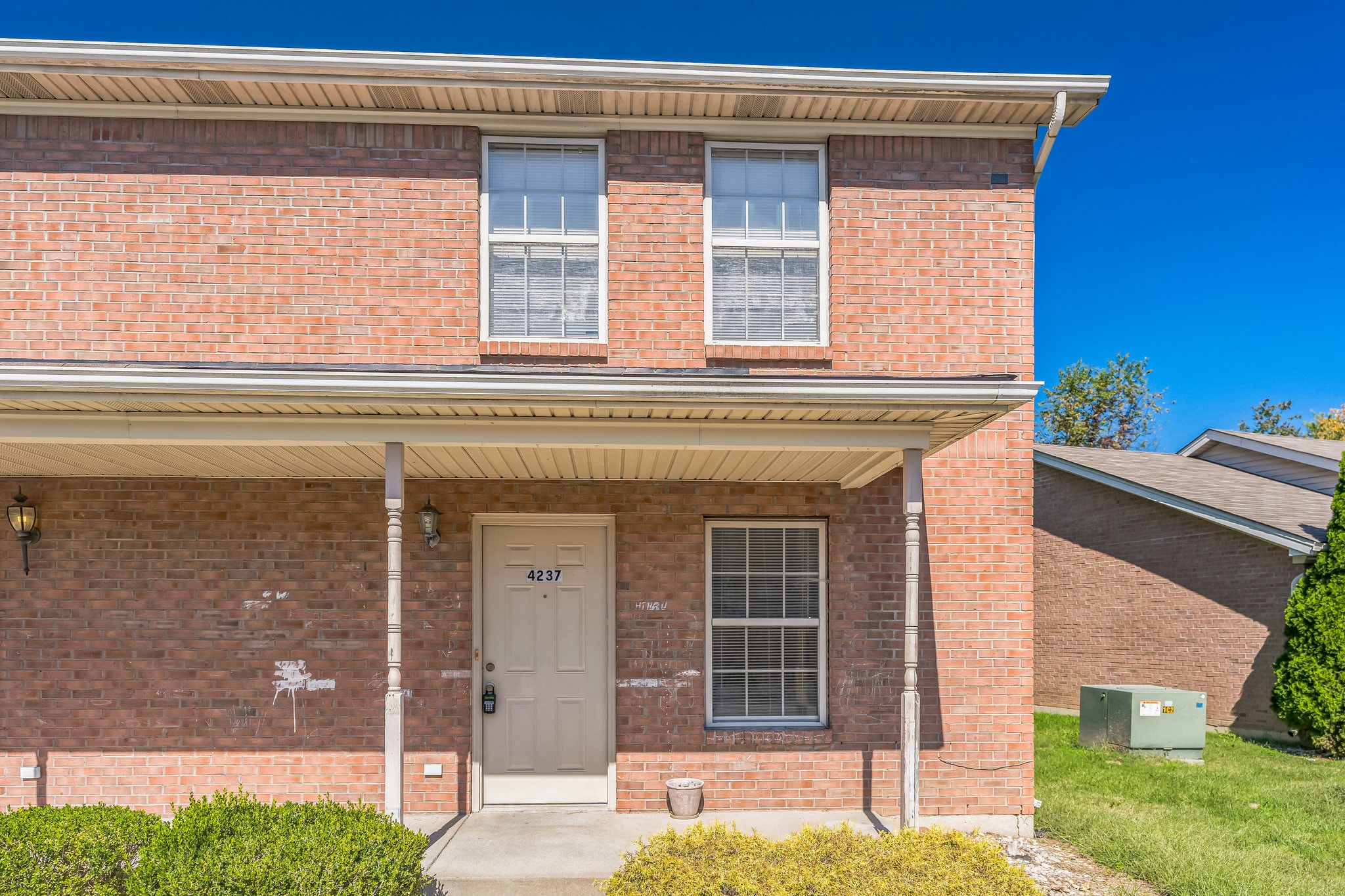 the front of a brick building with a white door