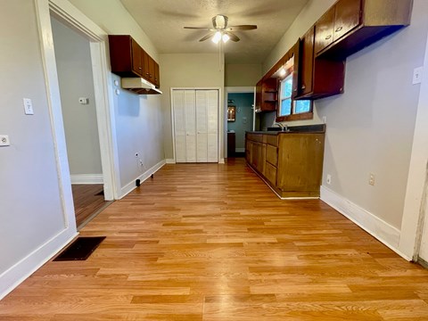 A kitchen with wooden floors and white walls.