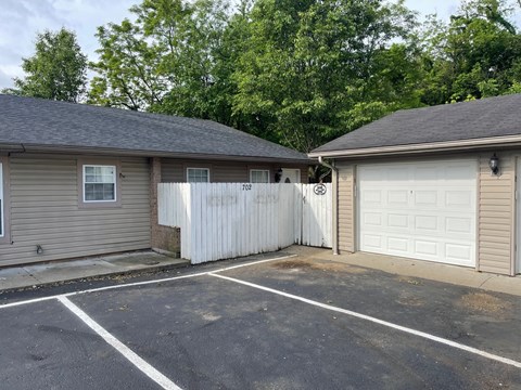 a garage and a white fence in front of a house