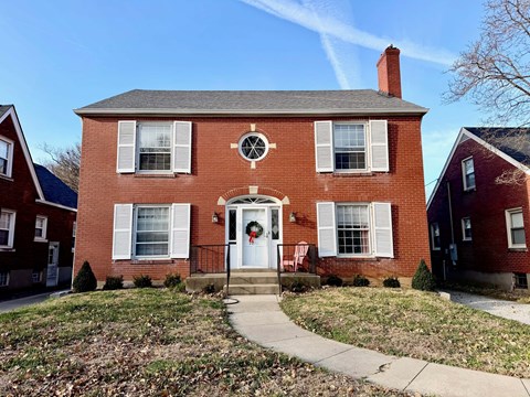 A red brick house with a white door and windows.