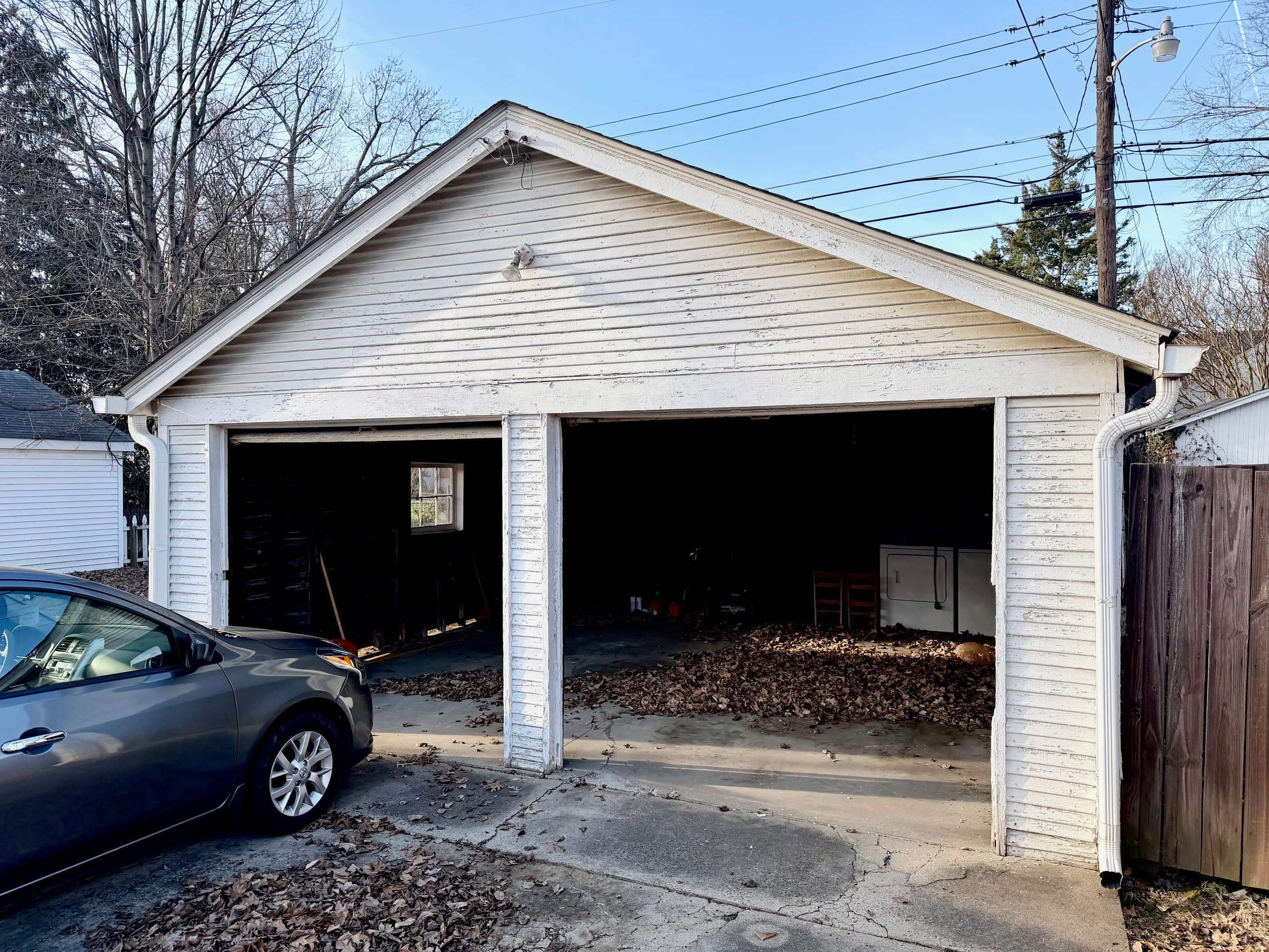 A garage with a car parked in front of it.