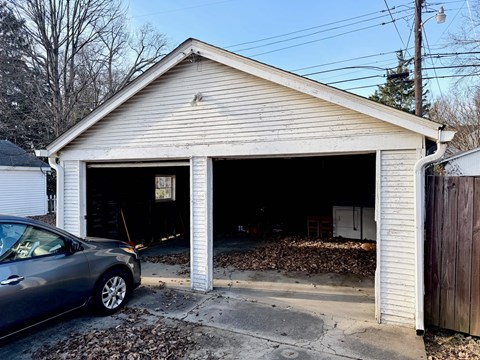 A garage with a car parked in front of it.