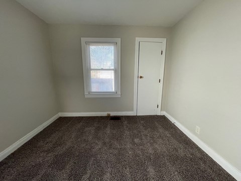 an empty room with carpet and a window