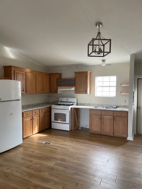 A kitchen with wooden cabinets and a white fridge.