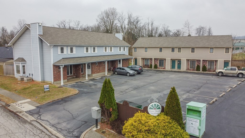 an aerial view of a parking lot in front of two houses