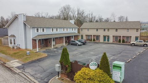 an aerial view of a parking lot in front of two houses