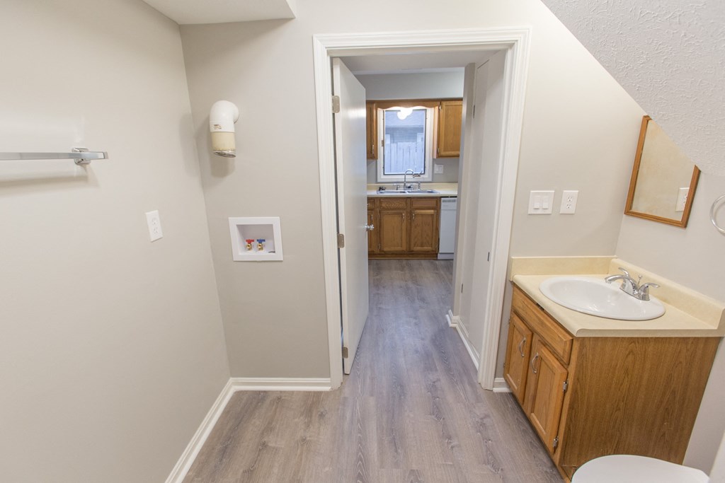 an empty bathroom with a sink and a toilet and a hallway to a bathroom with