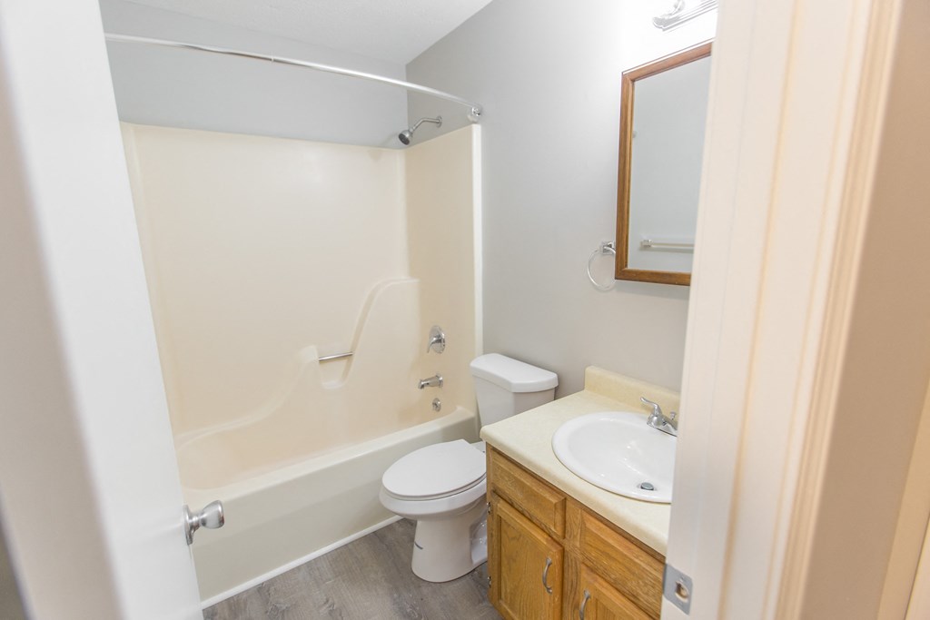 a bathroom with a toilet sink and tub and a mirror