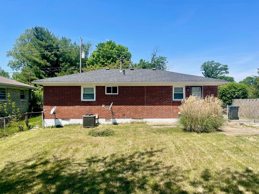 the front of a brick house with a yard and grass