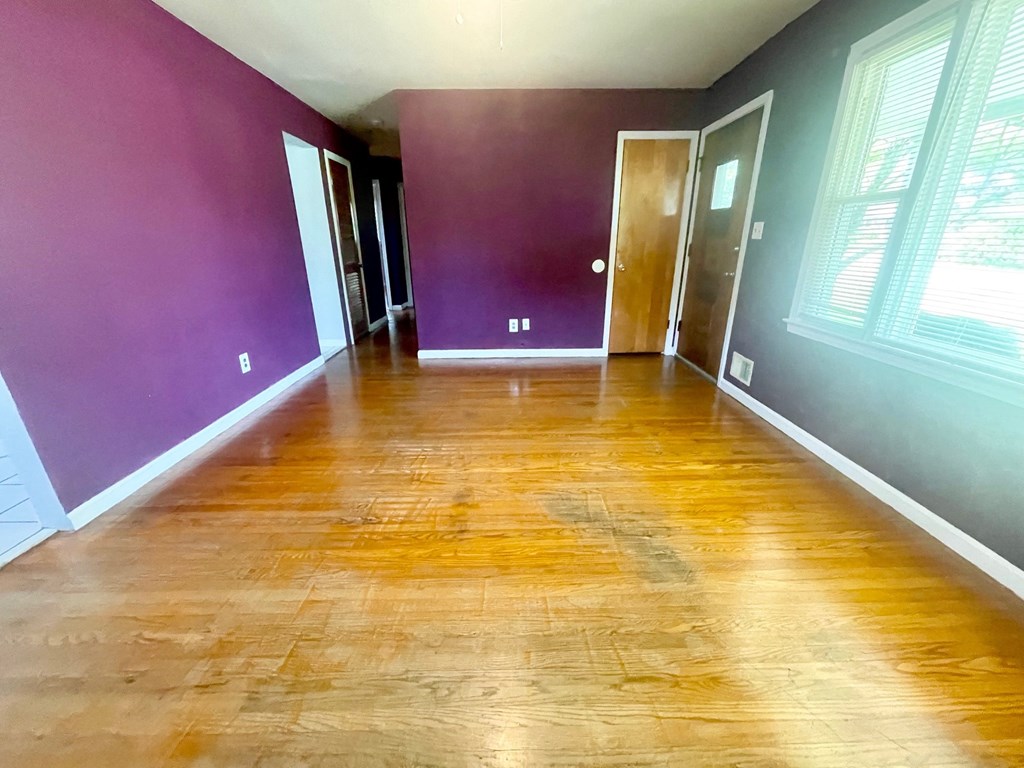 a empty room with purple walls and a wooden floor