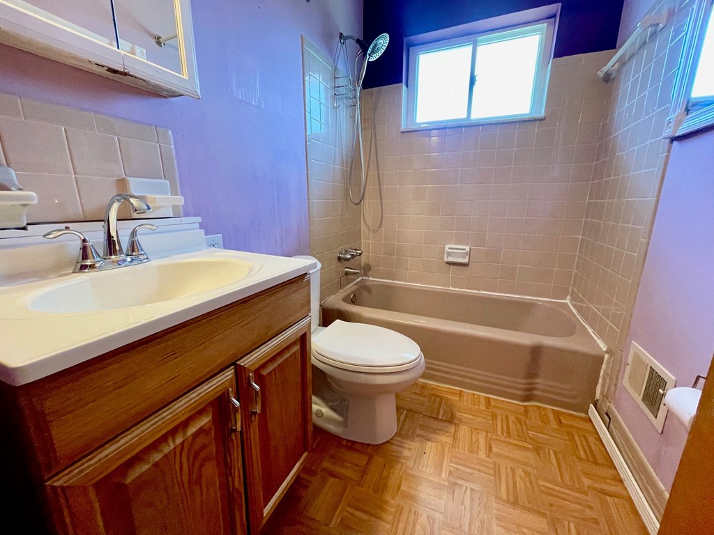 a bathroom with a toilet and a tub and a sink