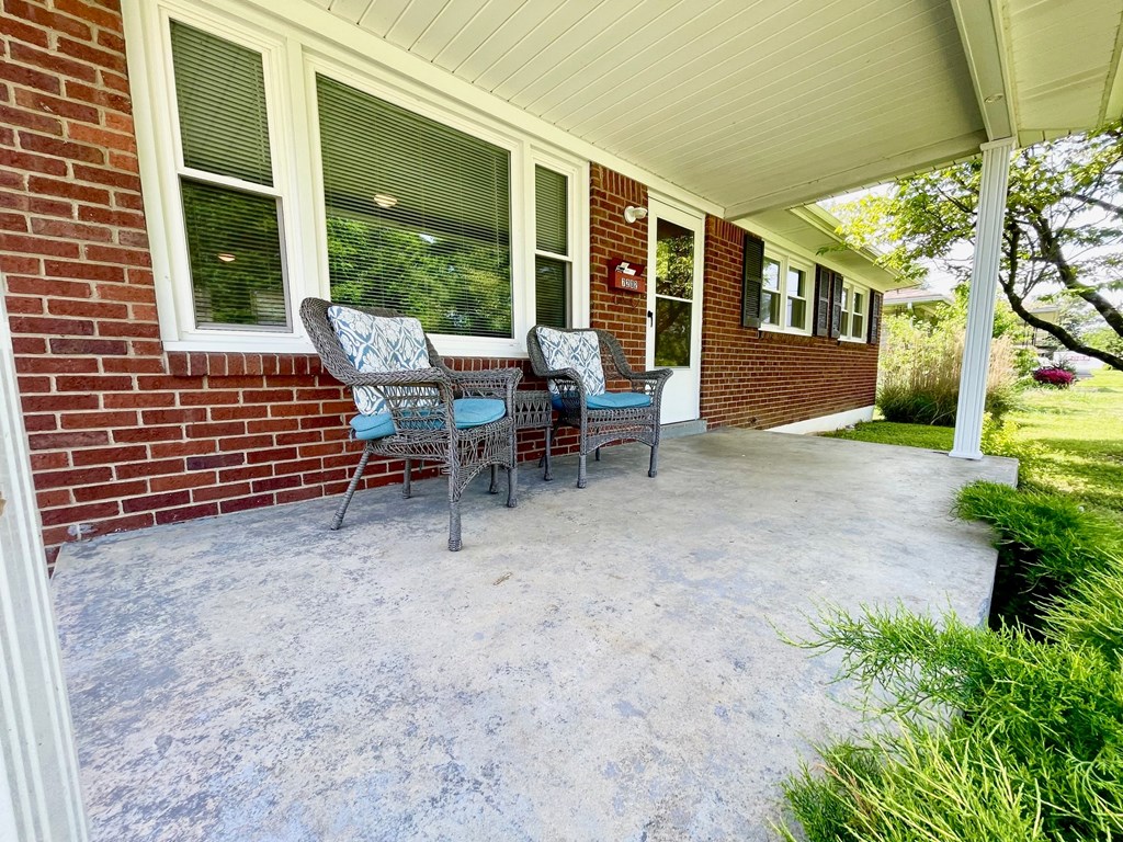 a covered patio with a table and chairs