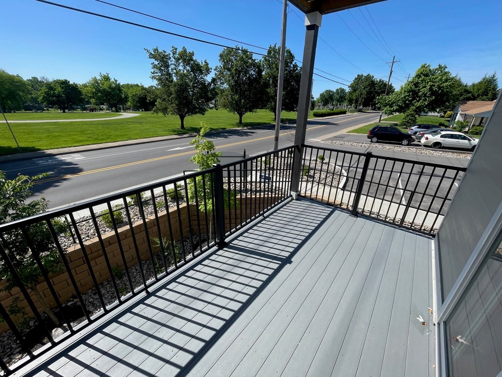 a view of a street from the balcony of a house
