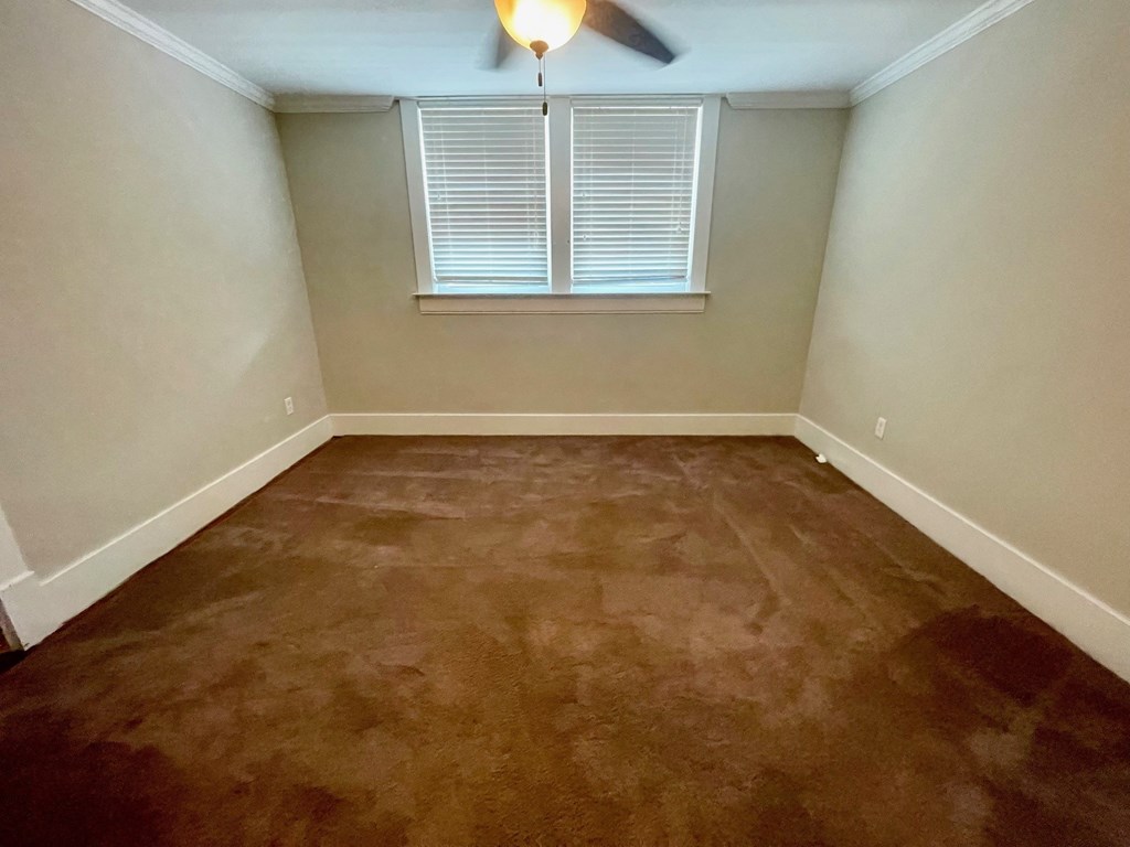 a empty room with a window and a ceiling fan