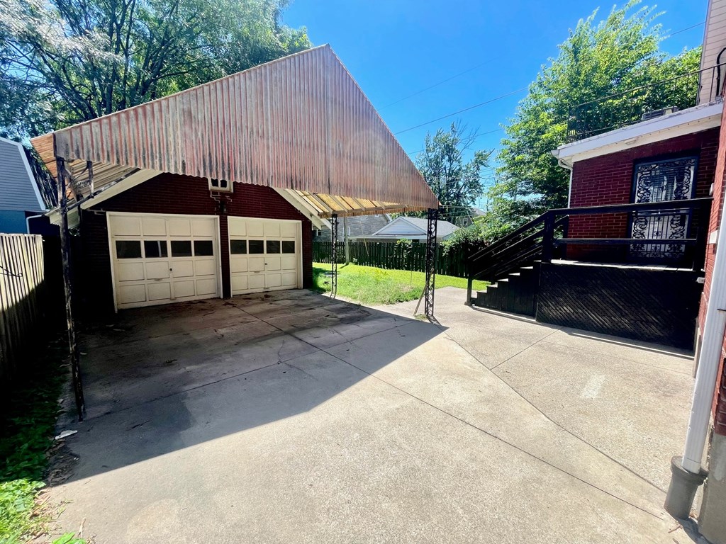 a garage with a barn style roof on top of a driveway