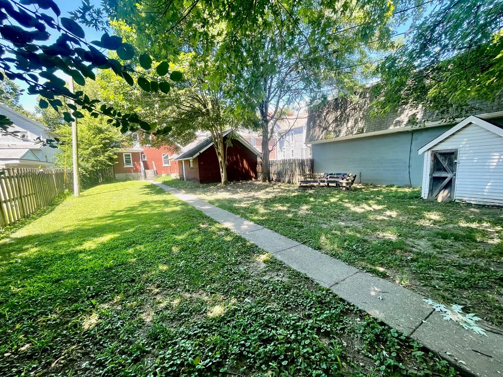 the backyard of a house with a yard and a sidewalk