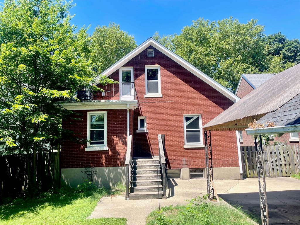 a red brick house with a porch and stairs