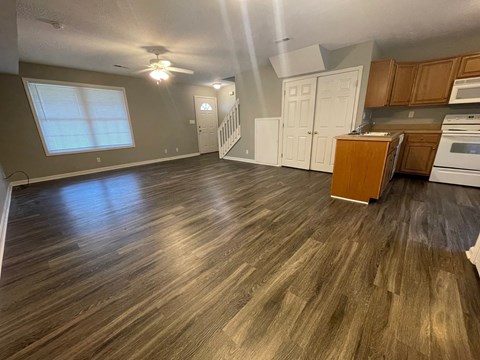 A kitchen with wooden floors and a stove top oven.