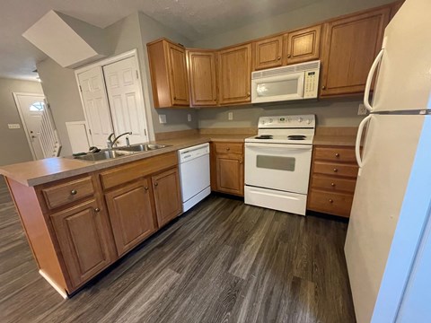 A kitchen with wooden cabinets and white appliances.