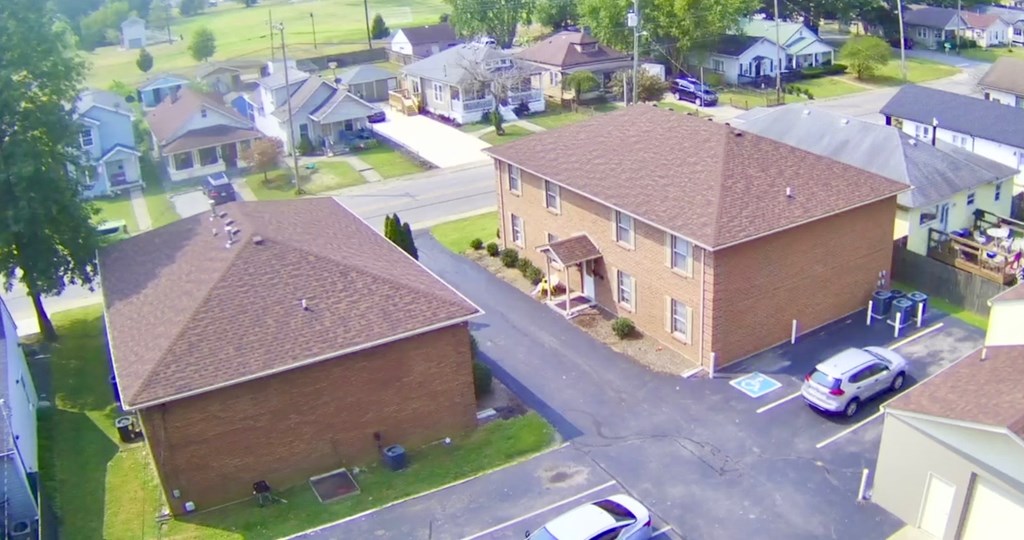 A bird's eye view of a residential area with houses and cars.