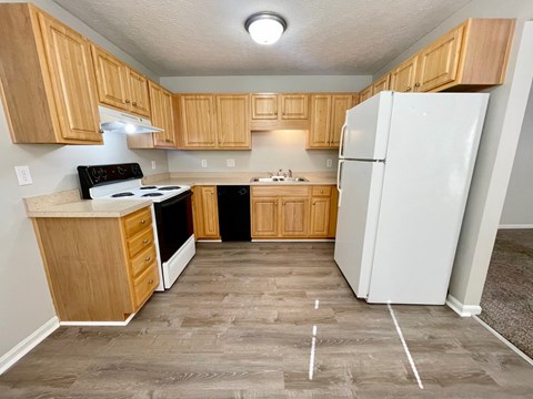 A kitchen with wooden cabinets and a white refrigerator.