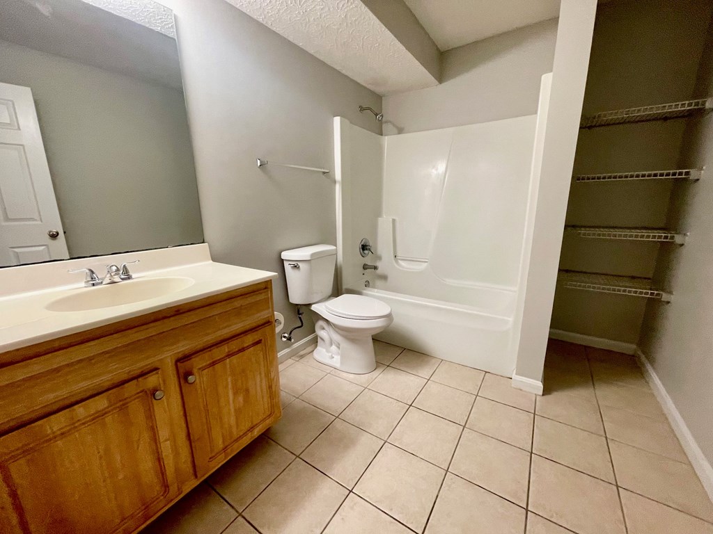 A bathroom with a toilet, sink, and shower.
