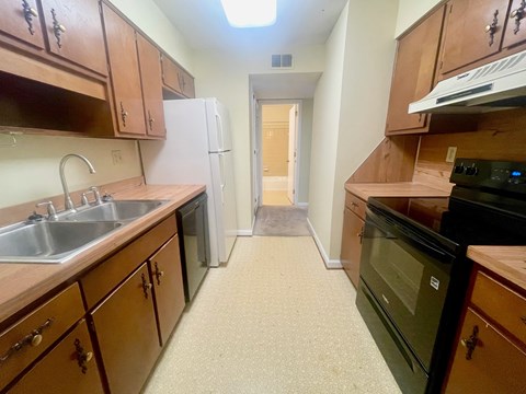 A kitchen with wooden cabinets and a black oven.
