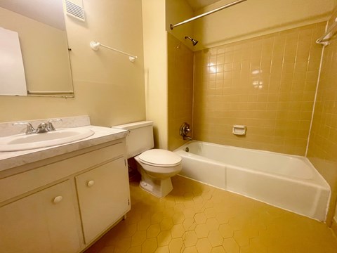 A bathroom with a toilet, sink, and bathtub.