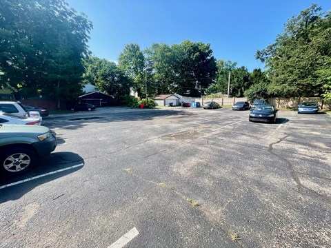 A parking lot with cars and trees in the background.