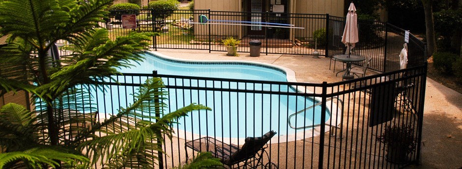 a swimming pool is shown behind a black fence