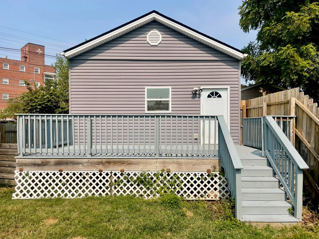 A grey house with a white picket fence in front.