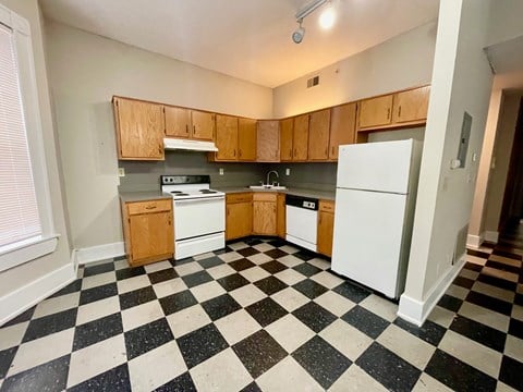 a kitchen with a checkered floor and white appliances