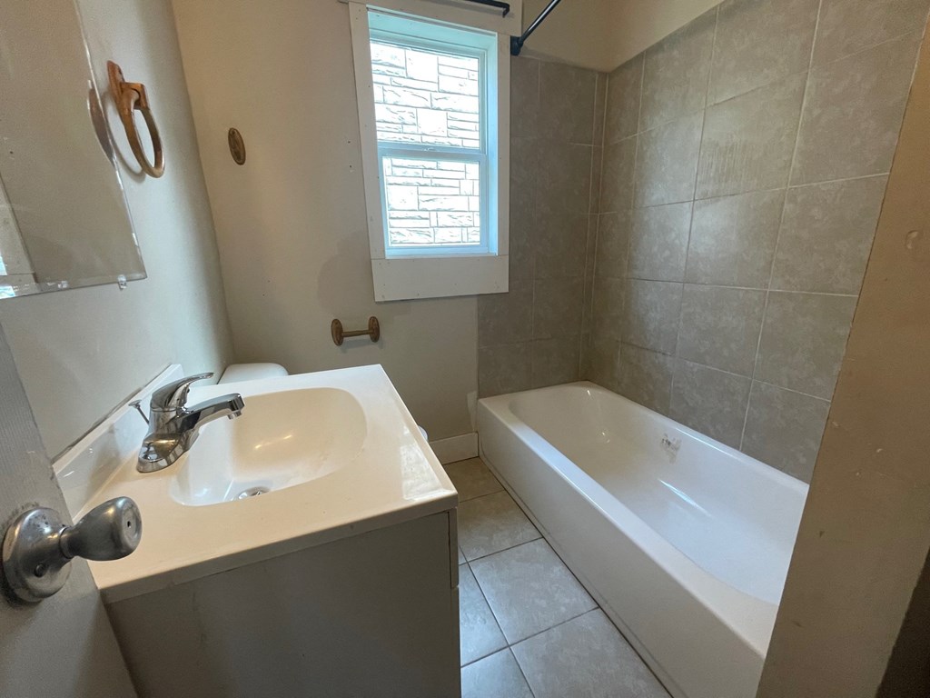 a bathroom with a sink and a tub and a window