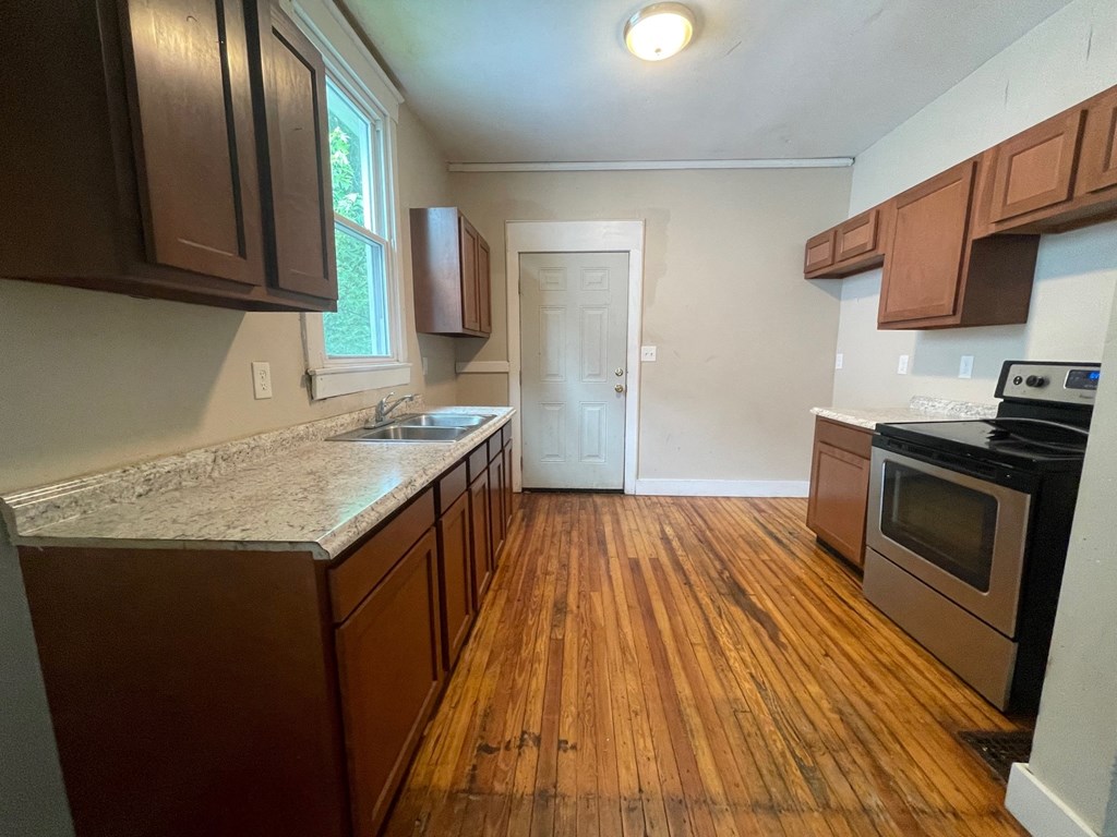 an empty kitchen with wooden floors and wooden cabinets