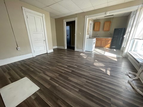 A room with wooden flooring and a white door.